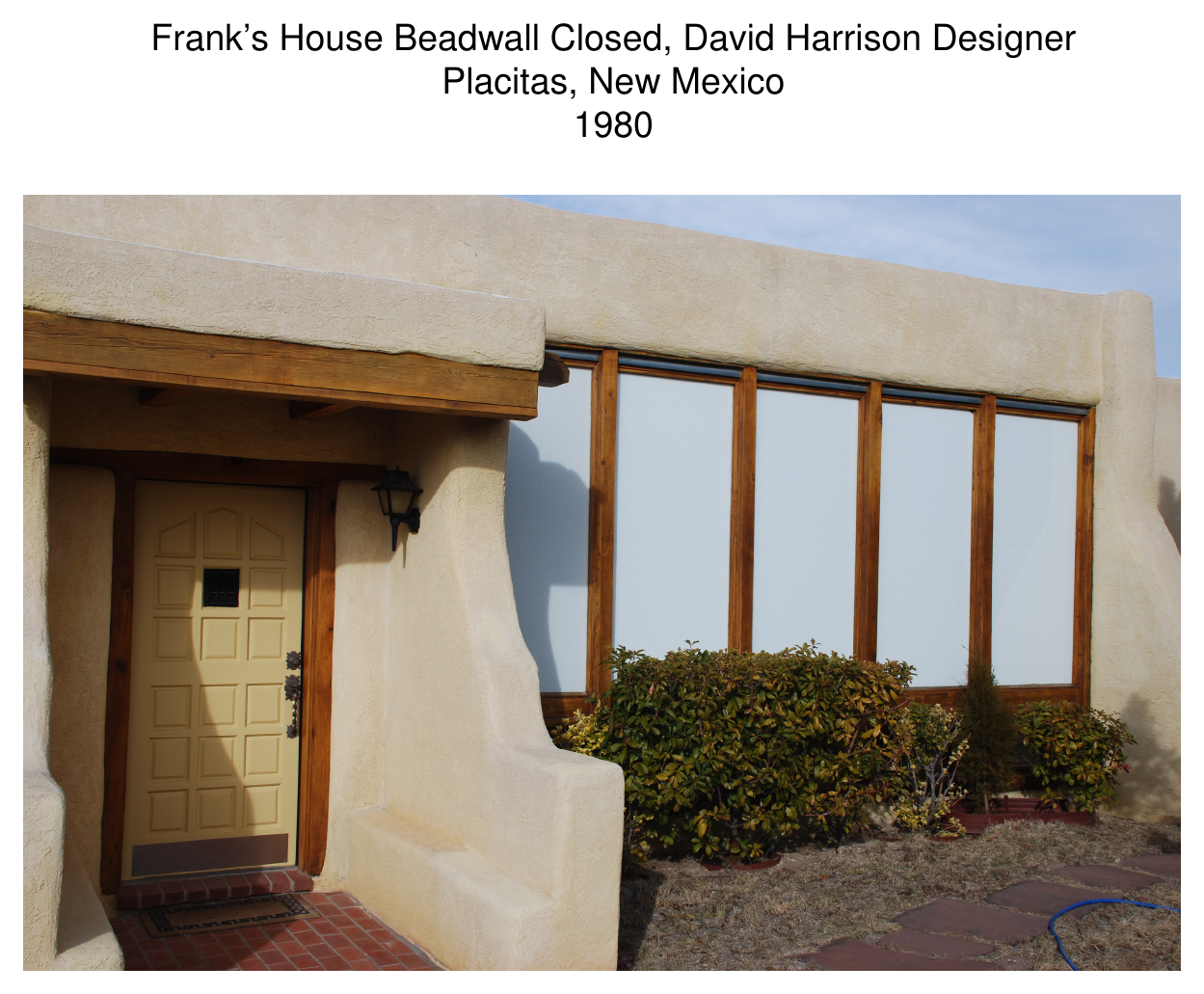 Exterior photograph of Frank's House with Beadwall windows closed — adobe wall with tall wood-framed glazing, Placitas, NM, 1980