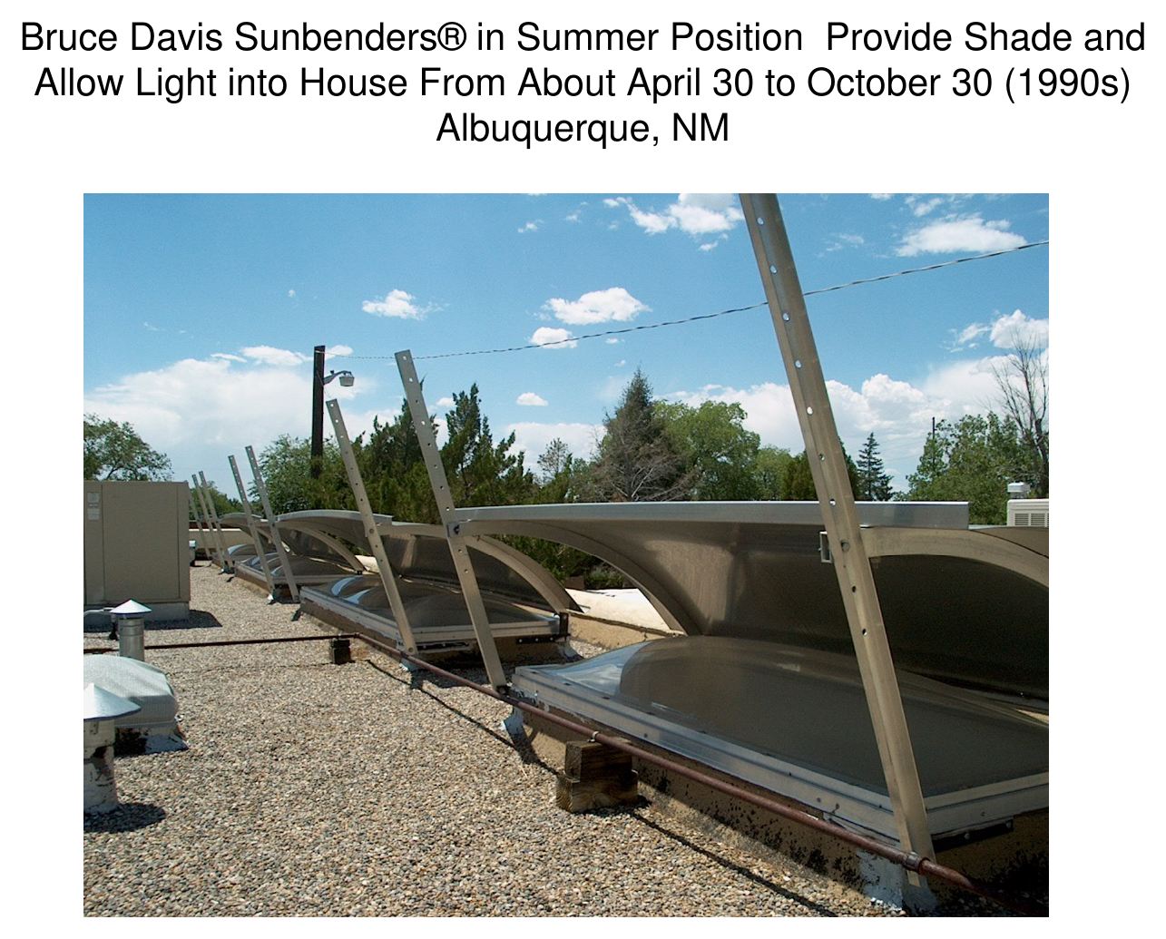 Rooftop photograph of Bruce Davis Sunbenders in summer position, angled aluminum reflector/shade panels over skylights, Albuquerque, NM